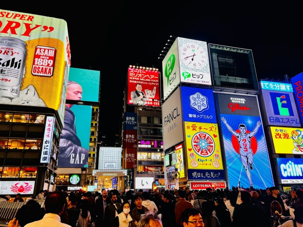 a crowded city street filled with lots of billboards Dotonbori